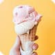 Pink ice cream cone in hand